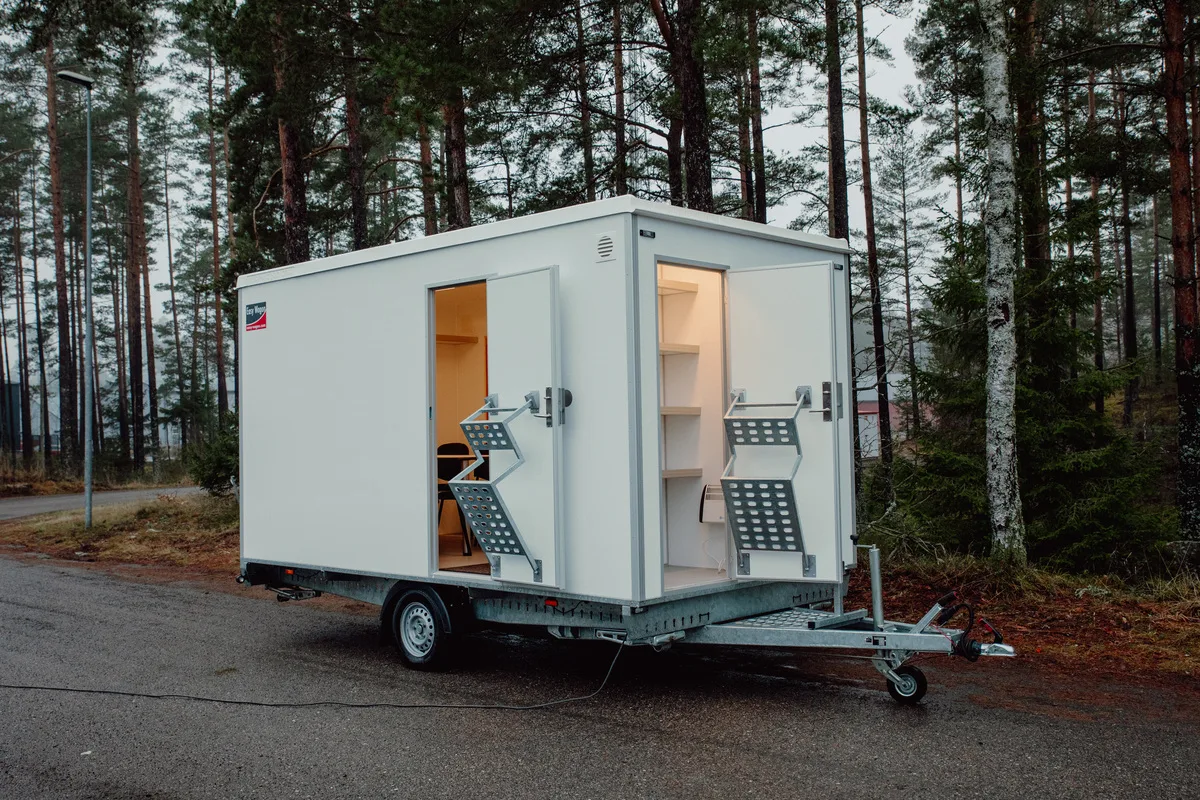 Vit rastvagn med öppna dörrar och sittgrupp