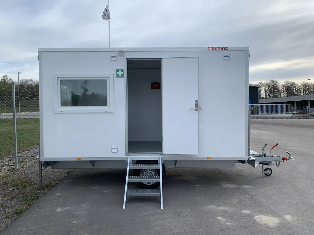 Vit rastvagn med fönster och öppen dörr